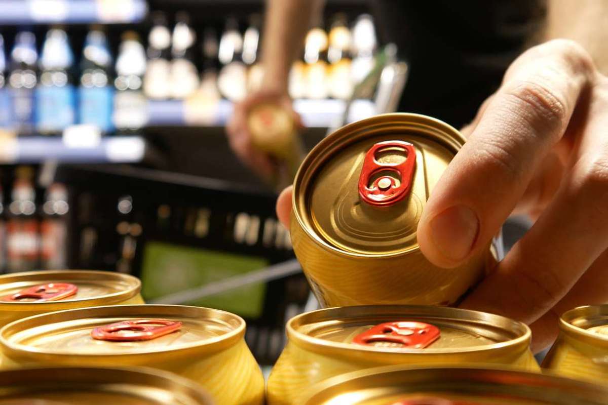 Shopper taking golden cans of beer