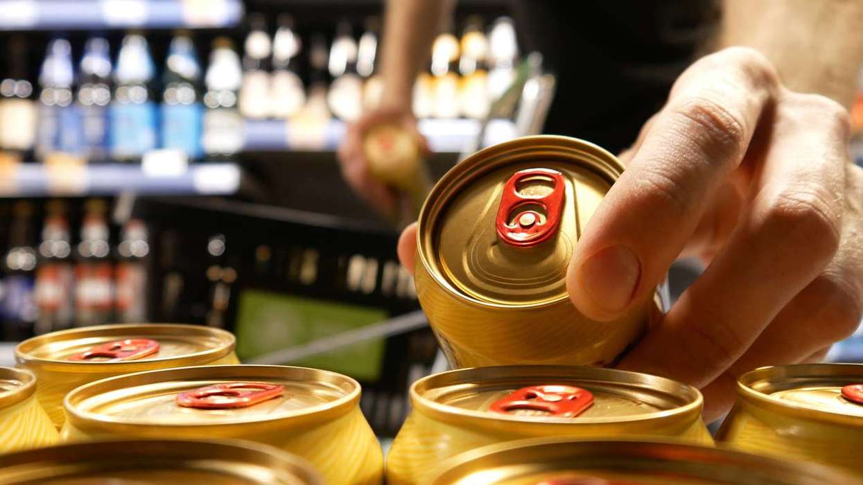 Shopper taking golden cans of beer