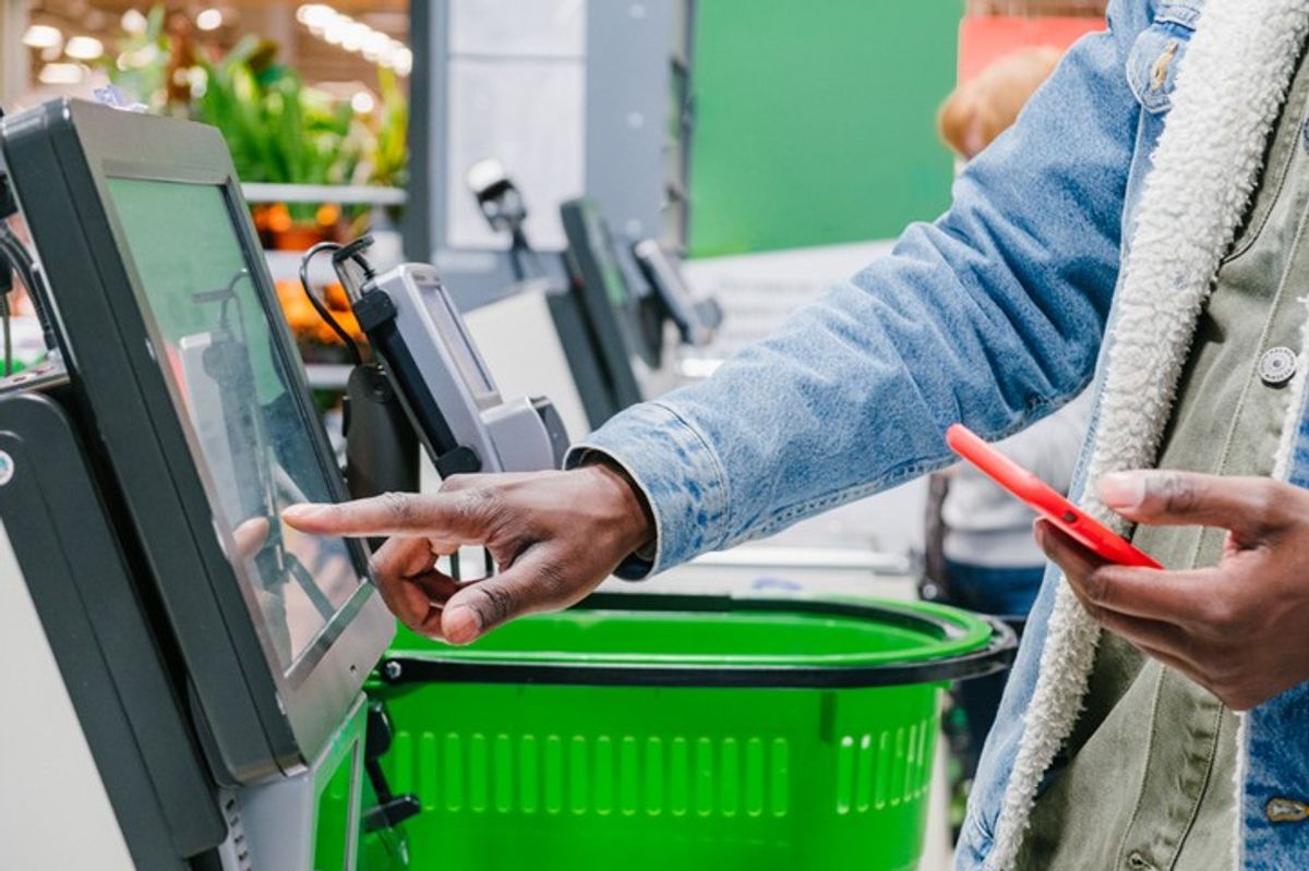 Shopper using technology in UK retail self-checkout in 2025