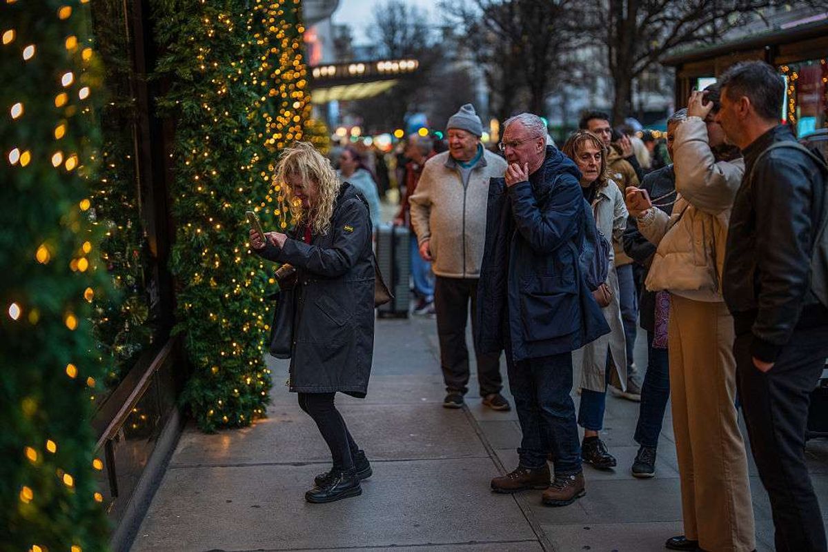 Shoppers view a festive display on a shop window