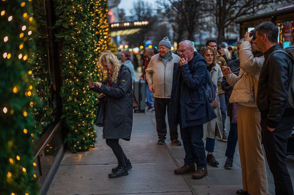 Shoppers view a festive display on a shop window