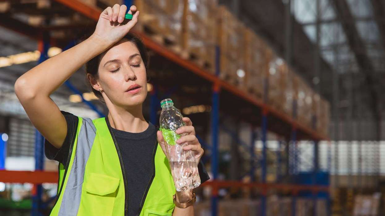 staff worker sweats from hot weather in summer working in warehouse