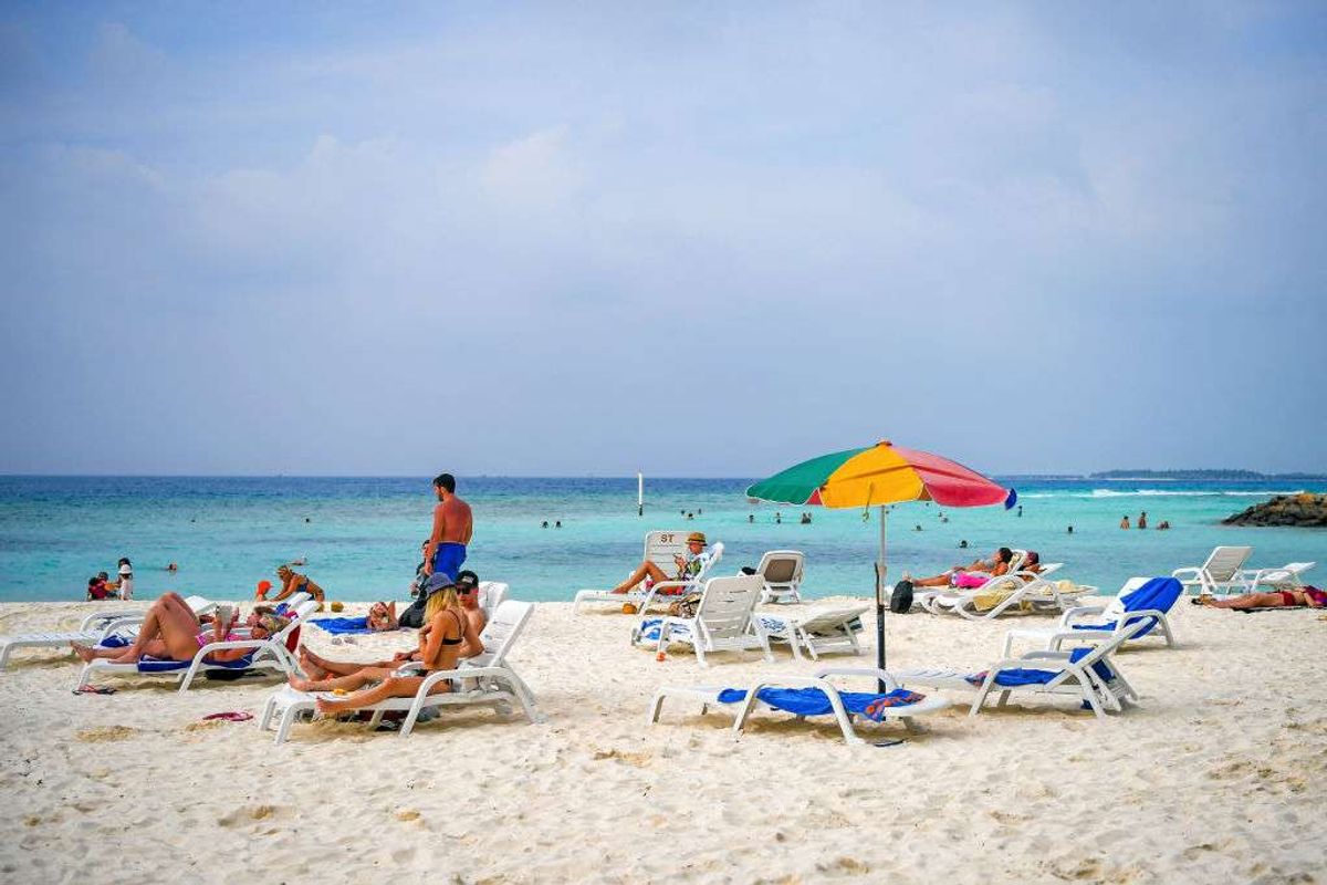 ​Tourists relax at a beach in Maafushi, an island in Maldives 