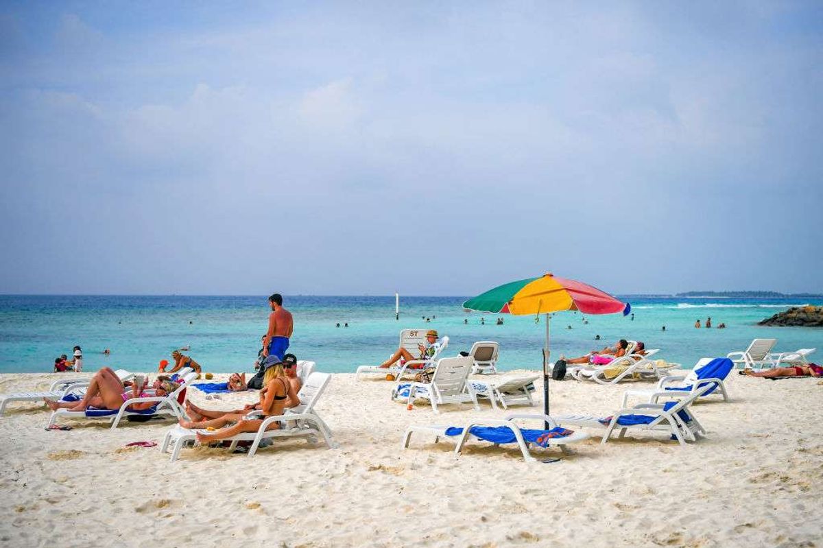 Tourists relax at a beach in Maafushi, an island in Maldives