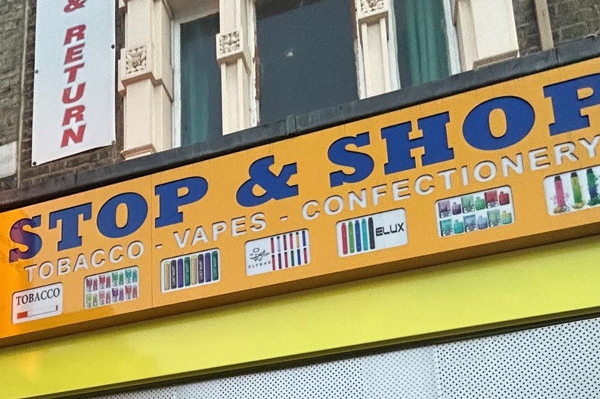 Trading standards officers raiding UK convenience store, uncovering hidden compartments with illicit tobacco, e-cigarettes, and THC-infused vapes.