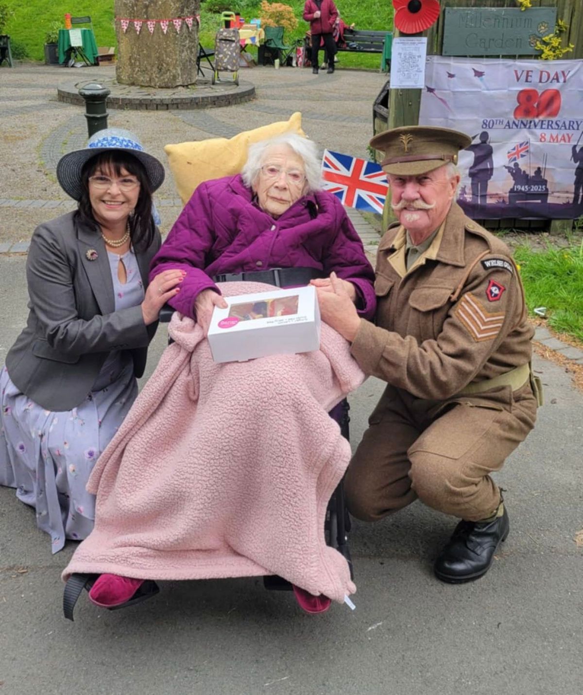 Trudy Davies with VE Day 80th brooches and picnic at Llanidloes community garden