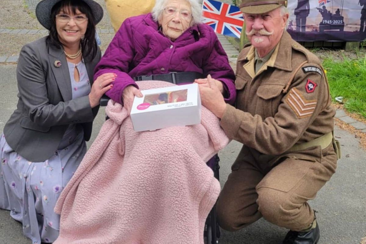 Trudy Davies with VE Day 80th brooches and picnic at Llanidloes community garden