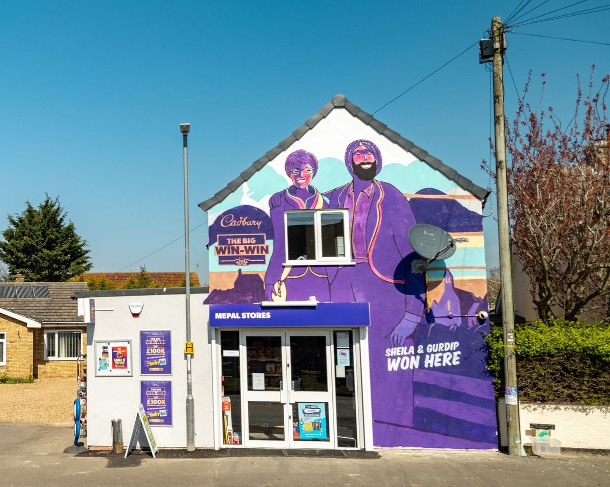 Winning retailer Gurdip Jatana and customer Sheila Thompson with Cadbury mural