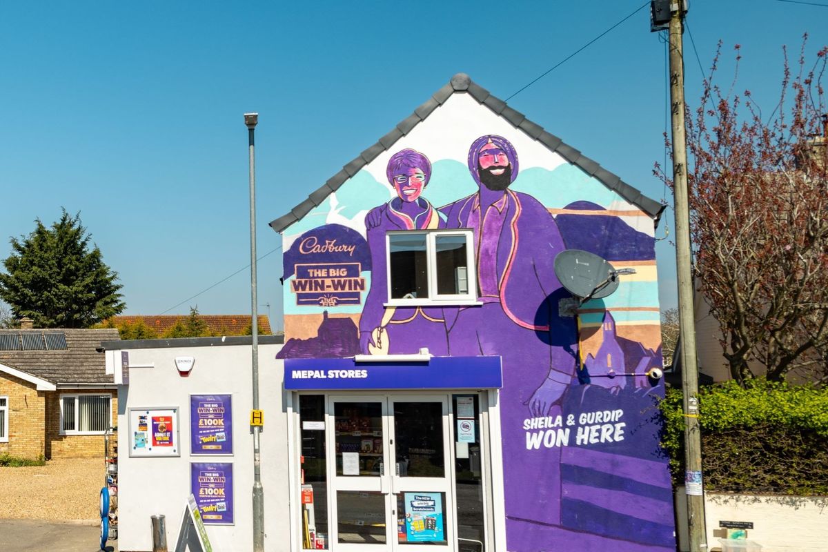Winning retailer Gurdip Jatana and customer Sheila Thompson with Cadbury mural