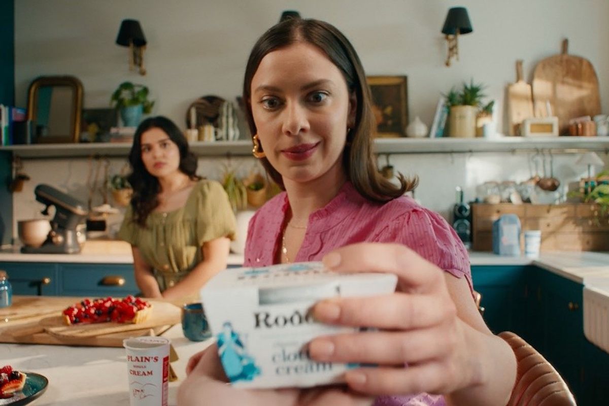 Woman offers Rodda’s clotted cream during dessert prep in vibrant kitchen scene from TV ad