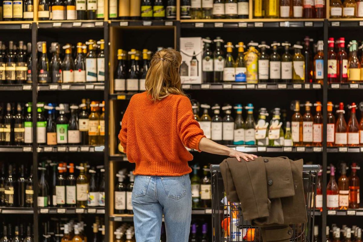 Woman shopping in a liquor store aisle 
