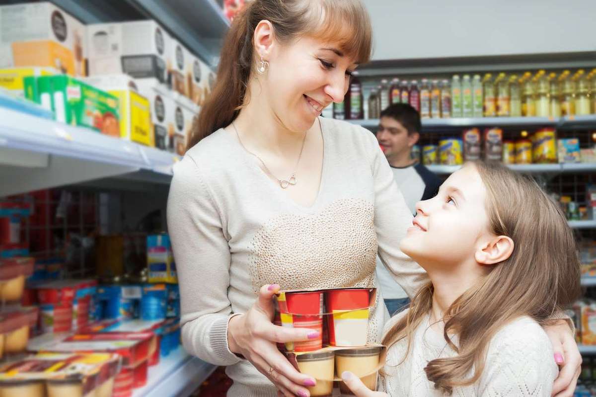 Woman with daughter buying sweet yoghurts