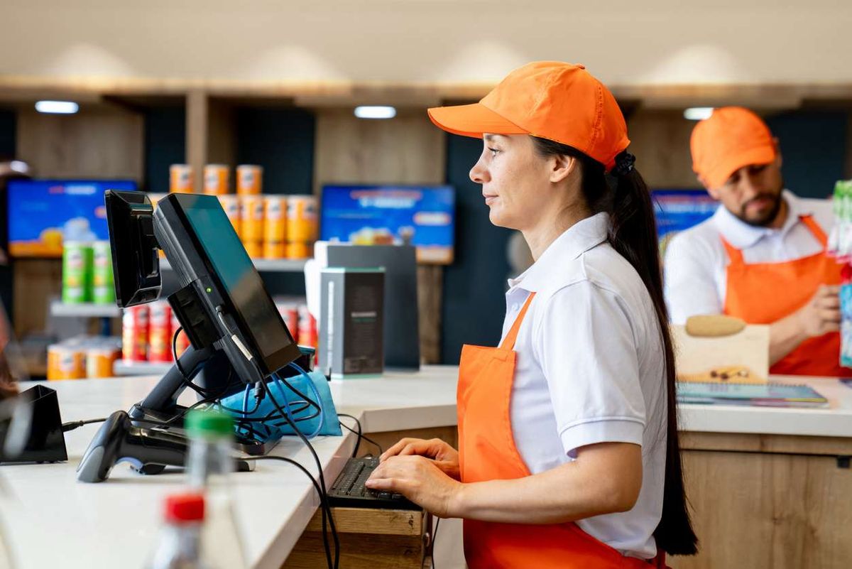 Woman working at the cashier in a convenience store 
