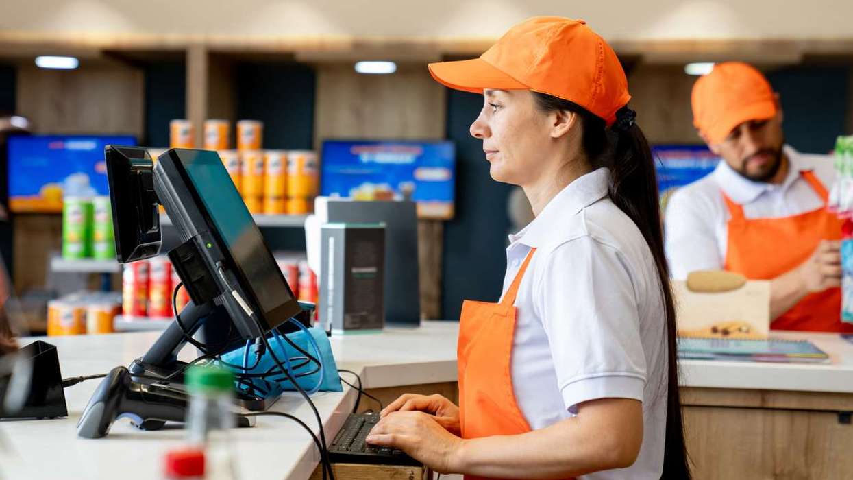 Woman working at the cashier in a convenience store