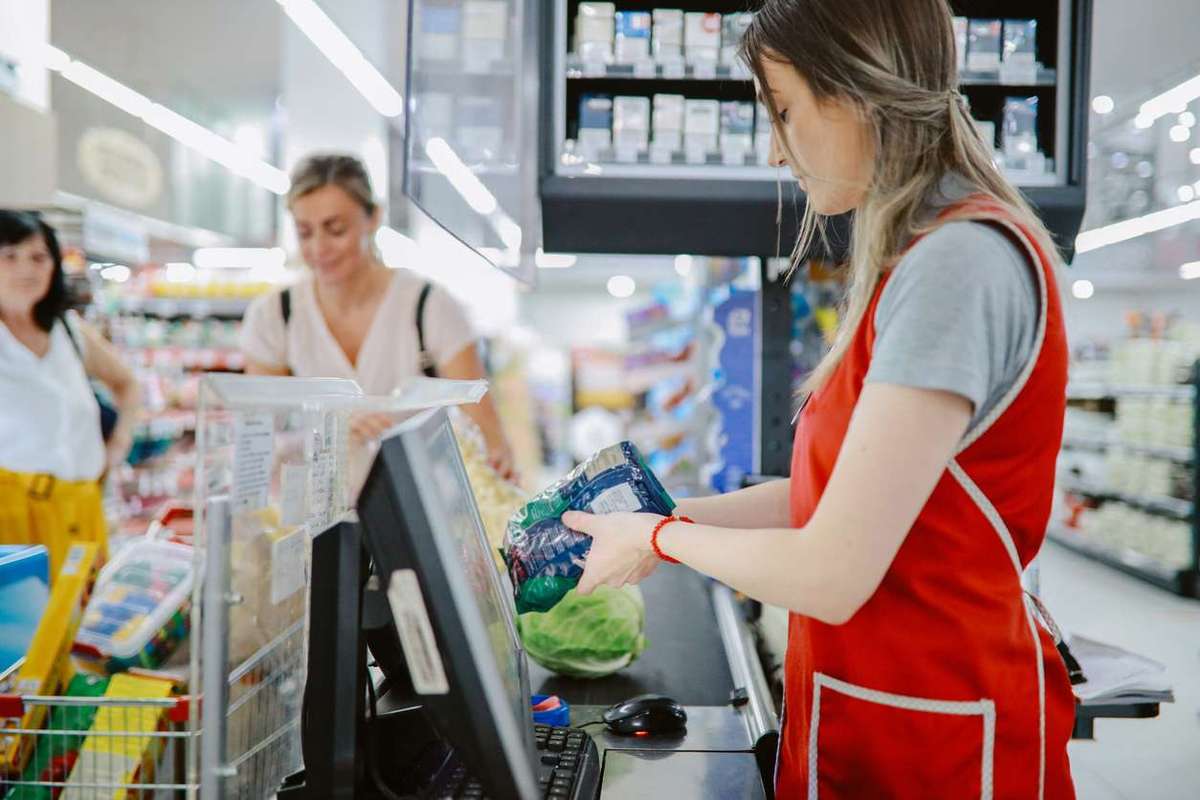 Woman working at the large supermarket checkout