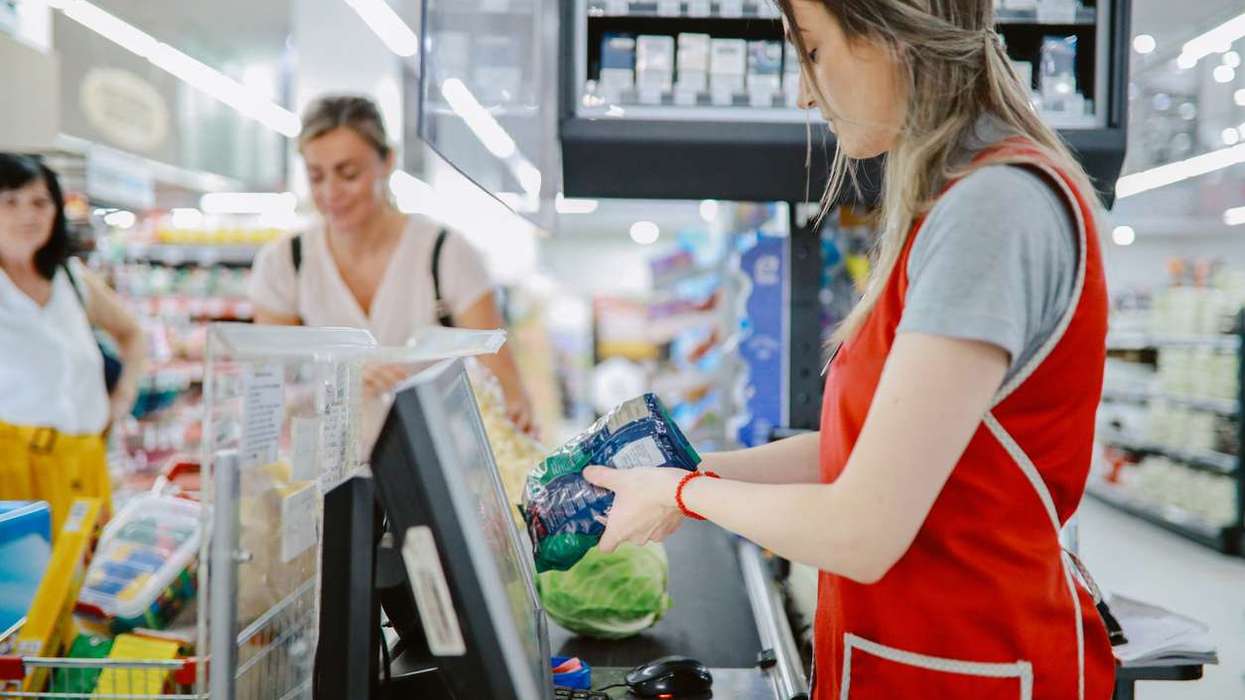 Woman working at the large supermarket checkout
