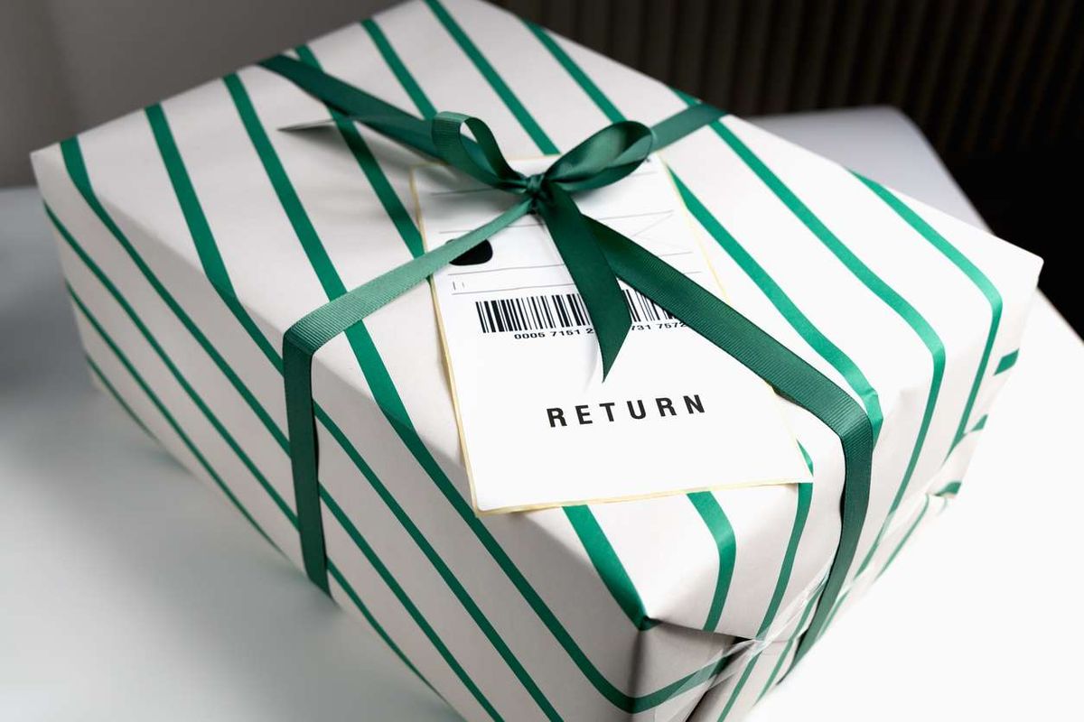 Wrapped gift box with return shipping label and green ribbon 