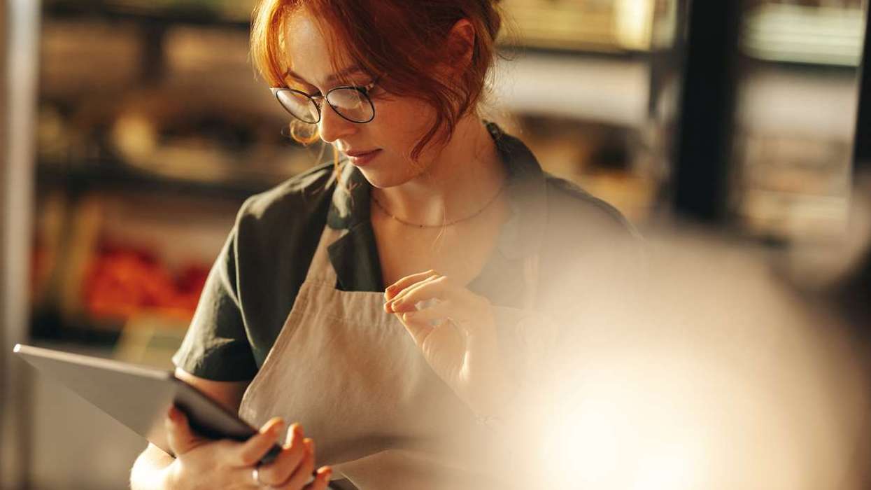 Young female entrepreneur taking inventory in her grocery store