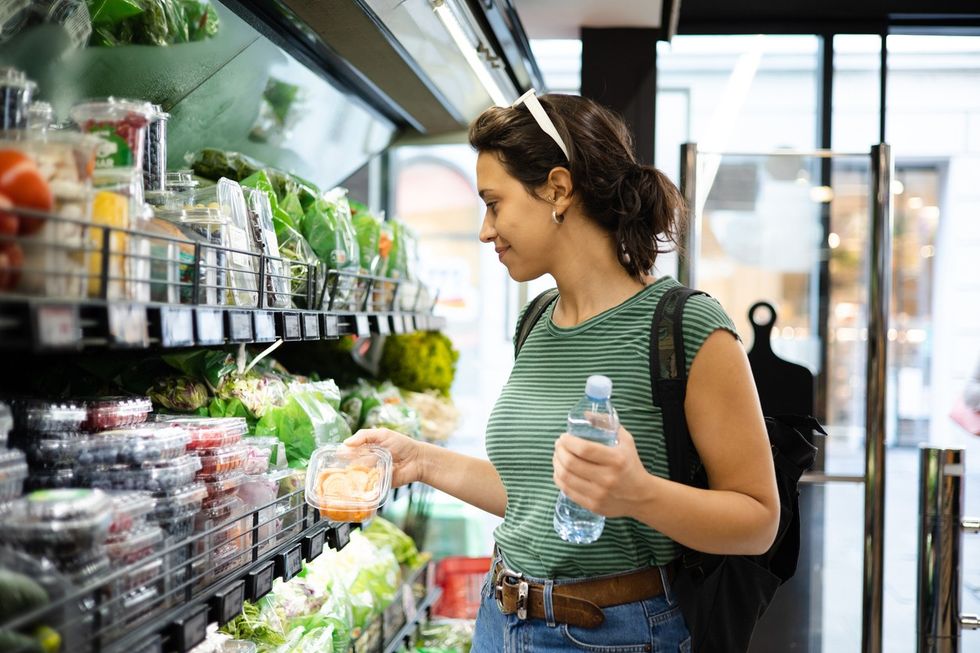 young woman buying fresh vegetables at the grocery store
